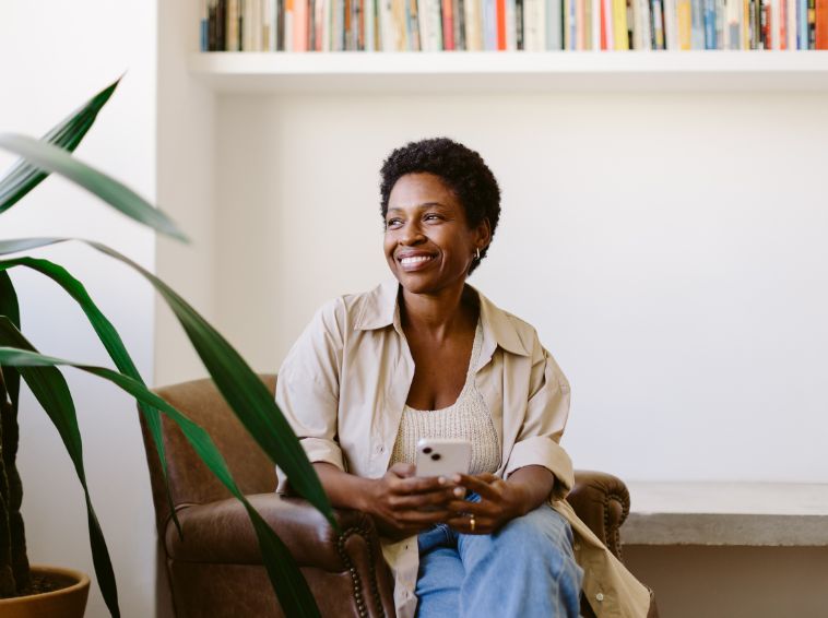 Woman sitting in chair looking out window and smiling